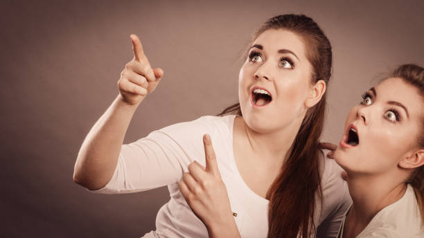 istock Happy women pointing up with one finger. 1304677513