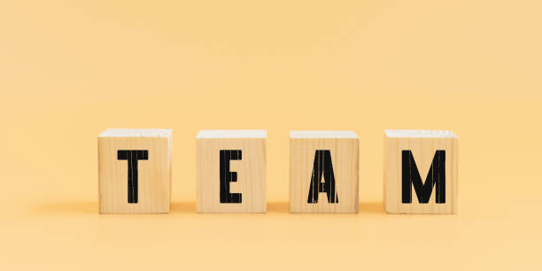 istock Team text on wood block on orange background. 1304677910