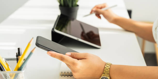 istock Woman using digital tablet with smartphone on the table in house. Blank screen for advertising. 1304678045
