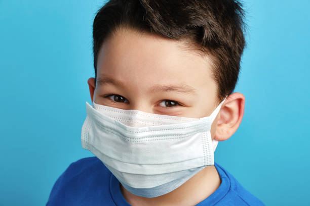 istock 8-9 years old cute child wearing double surgical mask 1304678057