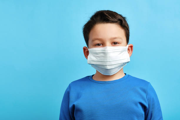 istock 8-9 years old cute child wearing double surgical mask 1304678071