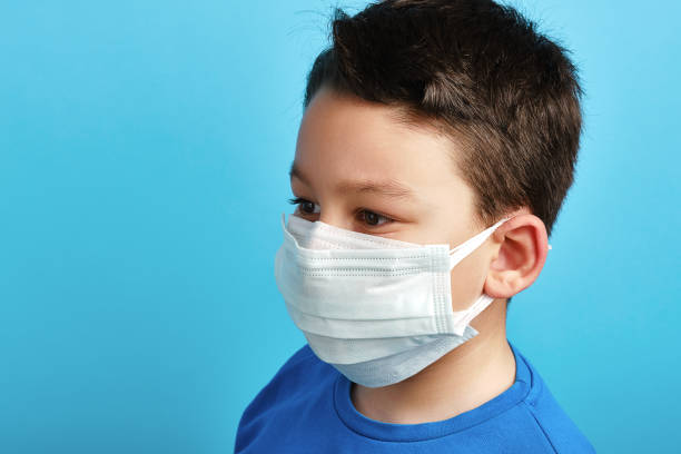 istock 8-9 years old cute child wearing double surgical mask 1304678080