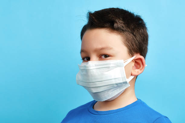 istock 8-9 years old cute child wearing double surgical mask 1304678082