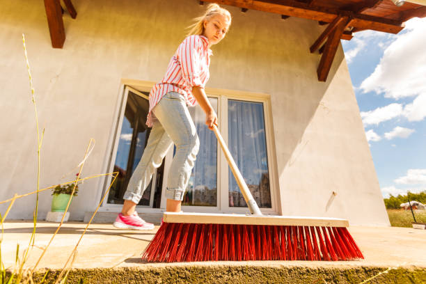 istock Woman cleaning patio using brush broom 1304678883