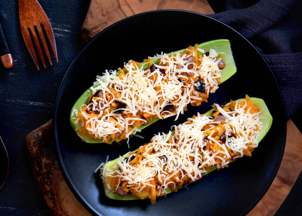 istock Stuffed zucchini with vegetables and cheese on a plate, top view 1304679254