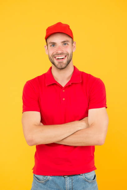 istock Courier and delivery service. Postman delivery worker. Man red cap yellow background. Delivering purchase. Already ready. Easing your business. Service delivery. Salesman and courier career 1304680485
