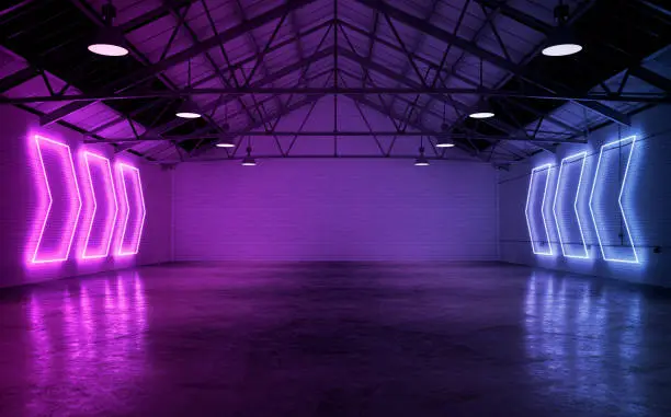 Photo of Empty warehouse interior illuminated by neon lights