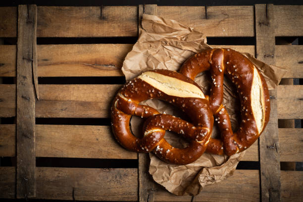 pretzel de pan alemán en una mesa de madera vista - pretzel german culture food salt fotografías e imágenes de stock