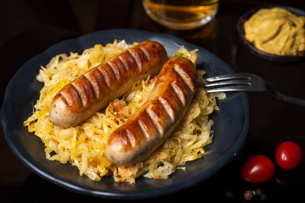 Bavarian sausages served with sauerkraut on a plate Bavarian fried sausages served with cooked sauerkraut sour cabbage on a plate tabletop view with food ingredients white cabbage stock pictures, royalty-free photos & images