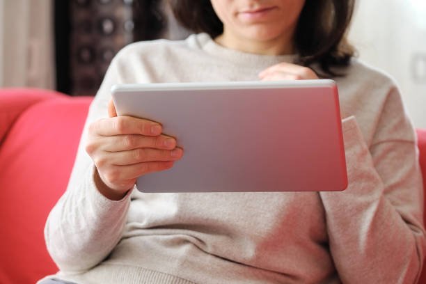 istock Happy woman using digital tablet on sofa at home 1304688052