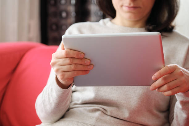 istock Happy woman using digital tablet on sofa at home 1304688074
