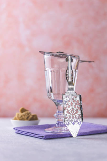 istock Set for absinthe drink. Glass and special spoons on light gray concrete table surface. 1304689281