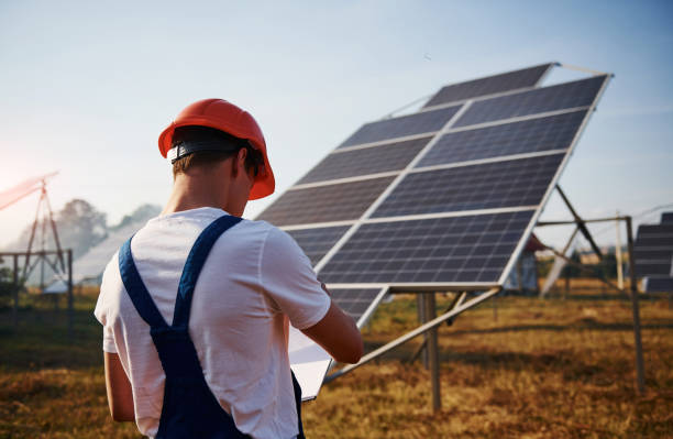 istock Male worker in blue uniform outdoors with solar batteries at sunny day 1304692364