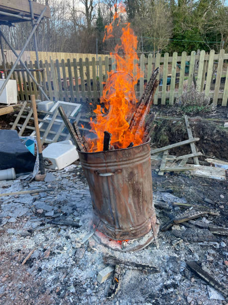istock Bonfire Burning in a Dilapidated Old Rusty Galvanised Metal Incinerator on a Building Site in Rural Devon, England, UK 1304692408