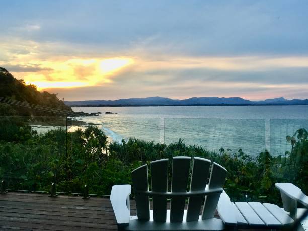 istock Watching Sunset Hour from White Deck Chairs at Beachside Property 1304692414