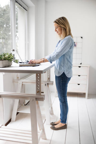 istock Businesswoman working at ergonomic standing workstation. 1304692868