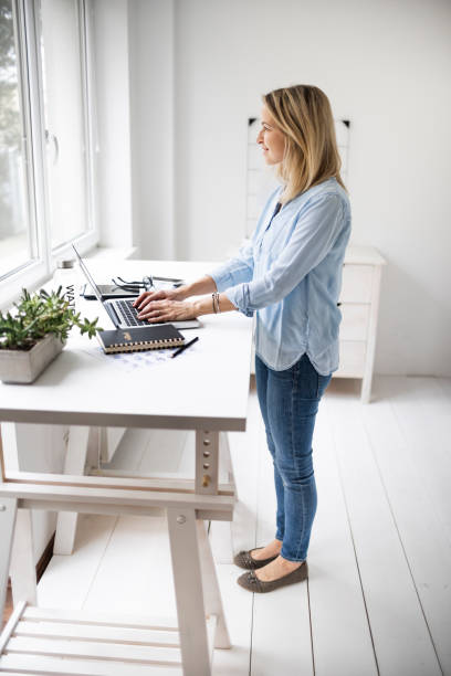 istock Businesswoman working at ergonomic standing workstation. 1304692872