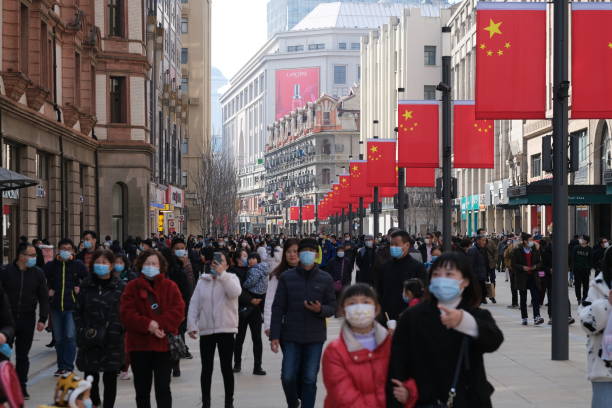 touristes bondés dans le masque facial, marchant sur la route de nanjing à changhaï - shanghaï photos et images de collection