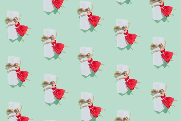 A blonde cute doll in a red dress blown on a white beverage box on a pastel green background. A blonde cute doll in a red dress blown on a white beverage box on a pastel green background. Minimal funny after party creative arrangement. drunk visual stock pictures, royalty-free photos & images
