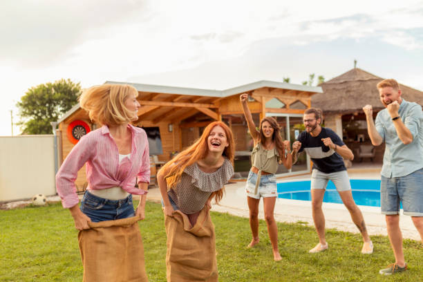 istock Friends racing by jumping in sacks in the backyard 1304695761