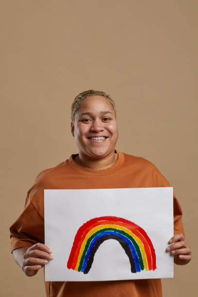 istock Mixed Race Woman Holding Rainbow Sign in Studio 1304696734