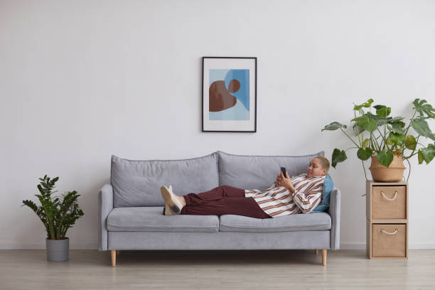 istock Contemporary Mixed Race Woman Relaxing on Sofa Side View 1304696800