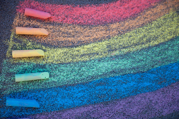 istock Chalk drawing. A rainbow painted on the asphalt with multicolored large crayons 1304699012