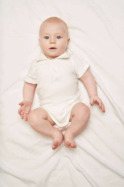 istock Cute small boy lying at bed. Childhood concept. Light background 1304700411