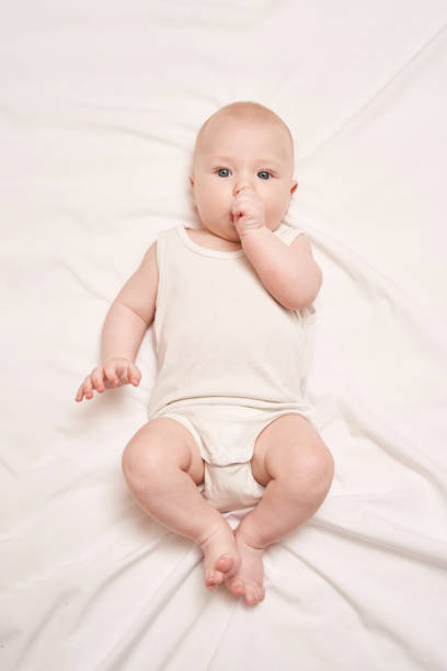 istock Cute small boy lying at bed. Childhood concept. Light background 1304700418