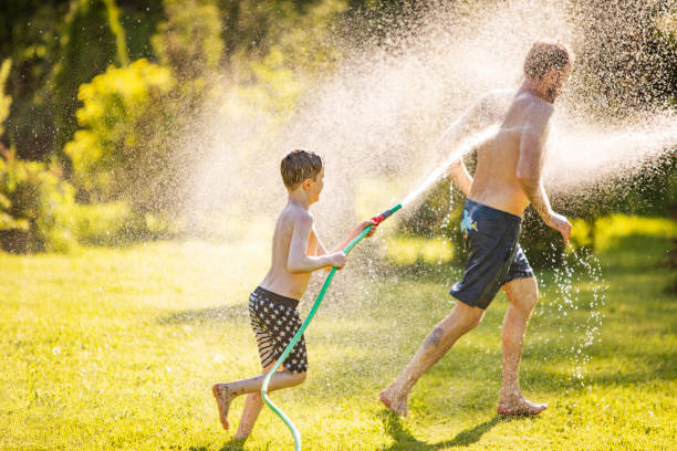 istock Father and son playing with water at backyard 1304701722