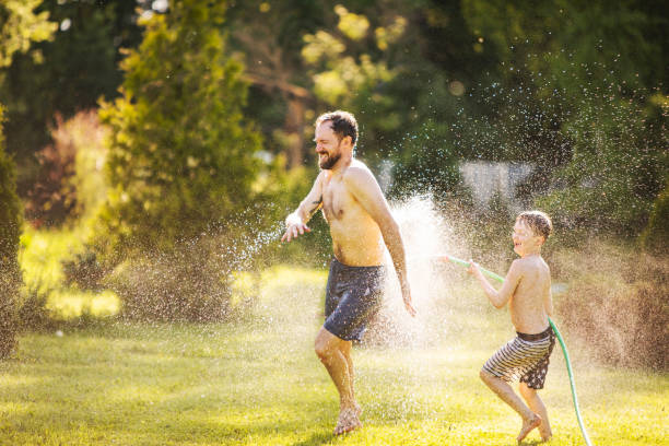 istock Father and son playing with water at backyard 1304701749