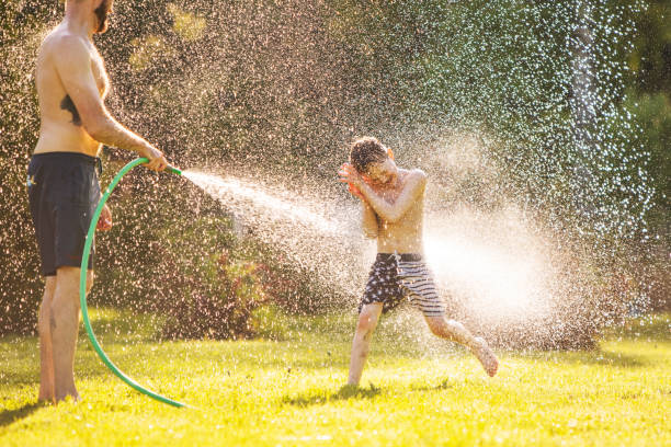 istock Father and son playing with water at backyard 1304701828