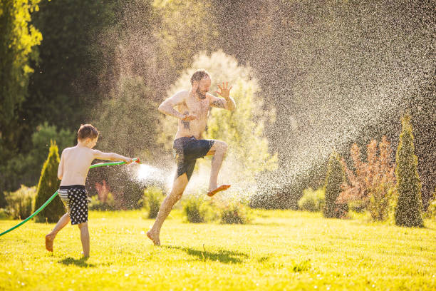 istock Father and son playing with water at backyard 1304701865