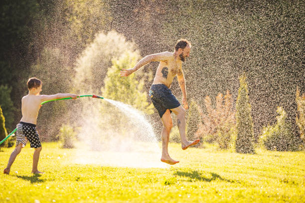 istock Father and son playing with water at backyard 1304701878