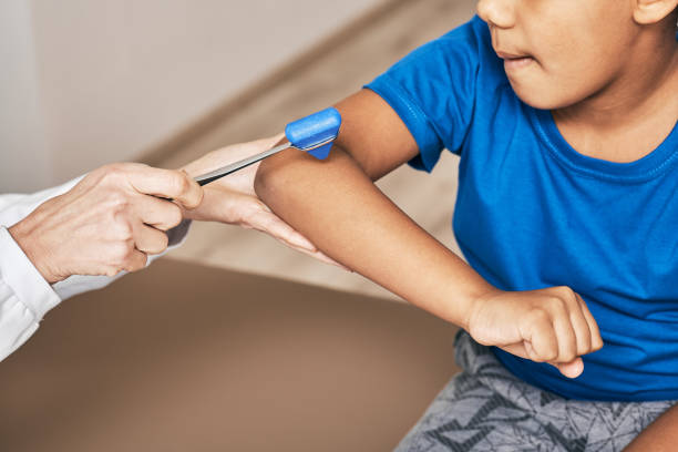 el médico utiliza un martillo neurológico para comprobar los reflejos del músculo bíceps de la mano del niño. examen neurológico - neurologic fotografías e imágenes de stock