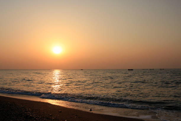istock Beautiful sunset with orange sky and shimmering sea 1304702460