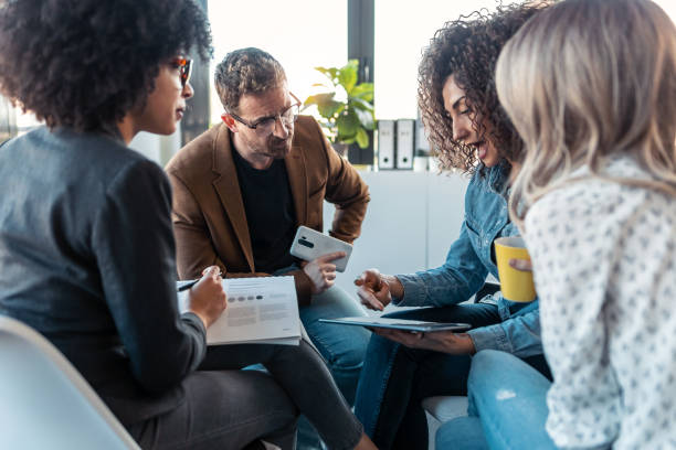 istock Casual multiage business people working with laptops while talking of they new project together in the office. 1304702687