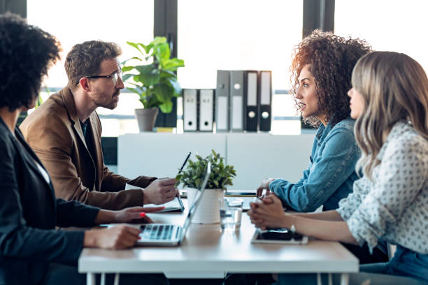 istock Casual multiage business people working with laptops while talking of they new project together in the office. 1304702832