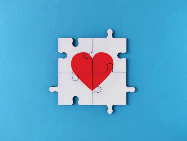 istock White jigsaw puzzle pieces forming a red heart on blue background 1304703617