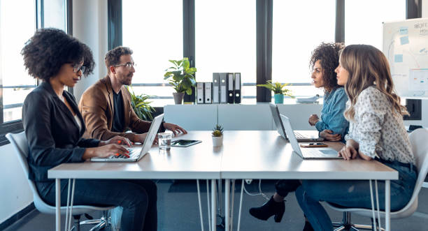 istock Casual multiage business people working with laptops while talking of they new project together in the office. 1304703802