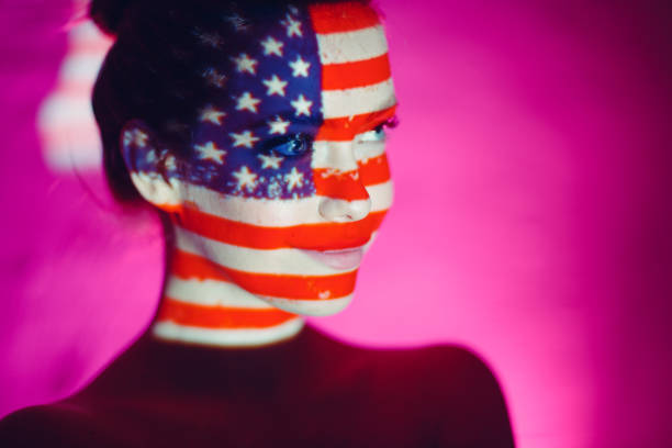 istock Young woman with USA flag on her face 1304705102