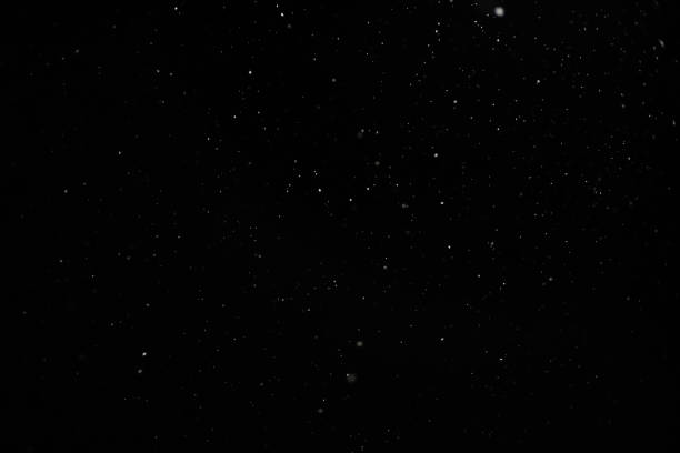 istock Snow against a black sky. Snow on a black background. Snow background. 1304705893