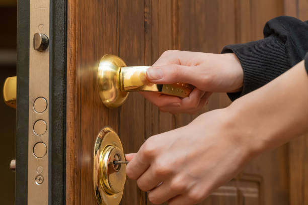 istock Woman's hands open a brown front door with a gold handle with a key close up 1304706057