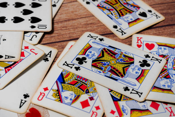 istock Deck of poker cards scattered on a wooden table. selective focus. 1304706725