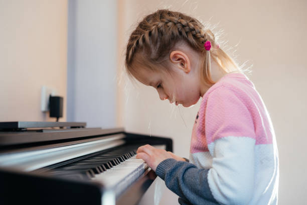 istock Little girl learning to play electric piano 1304708283