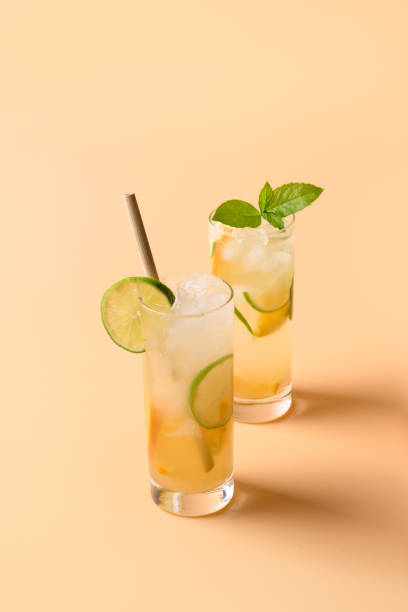 istock Refreshing orange two lemonade with lime slice on color background. Summer drink. 1304712656