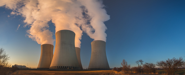 Temelin, Czech republic - 02 28 2021: Nuclear Power Plant Temelin, Steaming cooling towers in the landscape at sunset