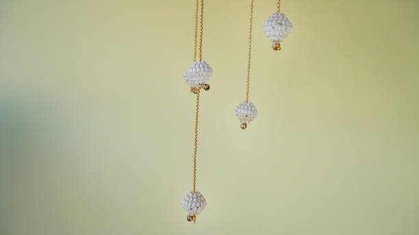 istock White wind chimes with diamonds and golden chain isolated on white background 1304715001