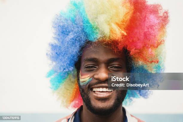 Happy Young African Man Wearing Lgbt Rainbow Flag Wig Focus On Face Stock Photo - Download Image Now