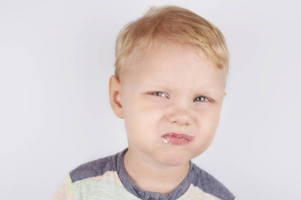 istock Three-year-old smiling boy with a mouth smeared with cake crumbs on a white background. 1304716622